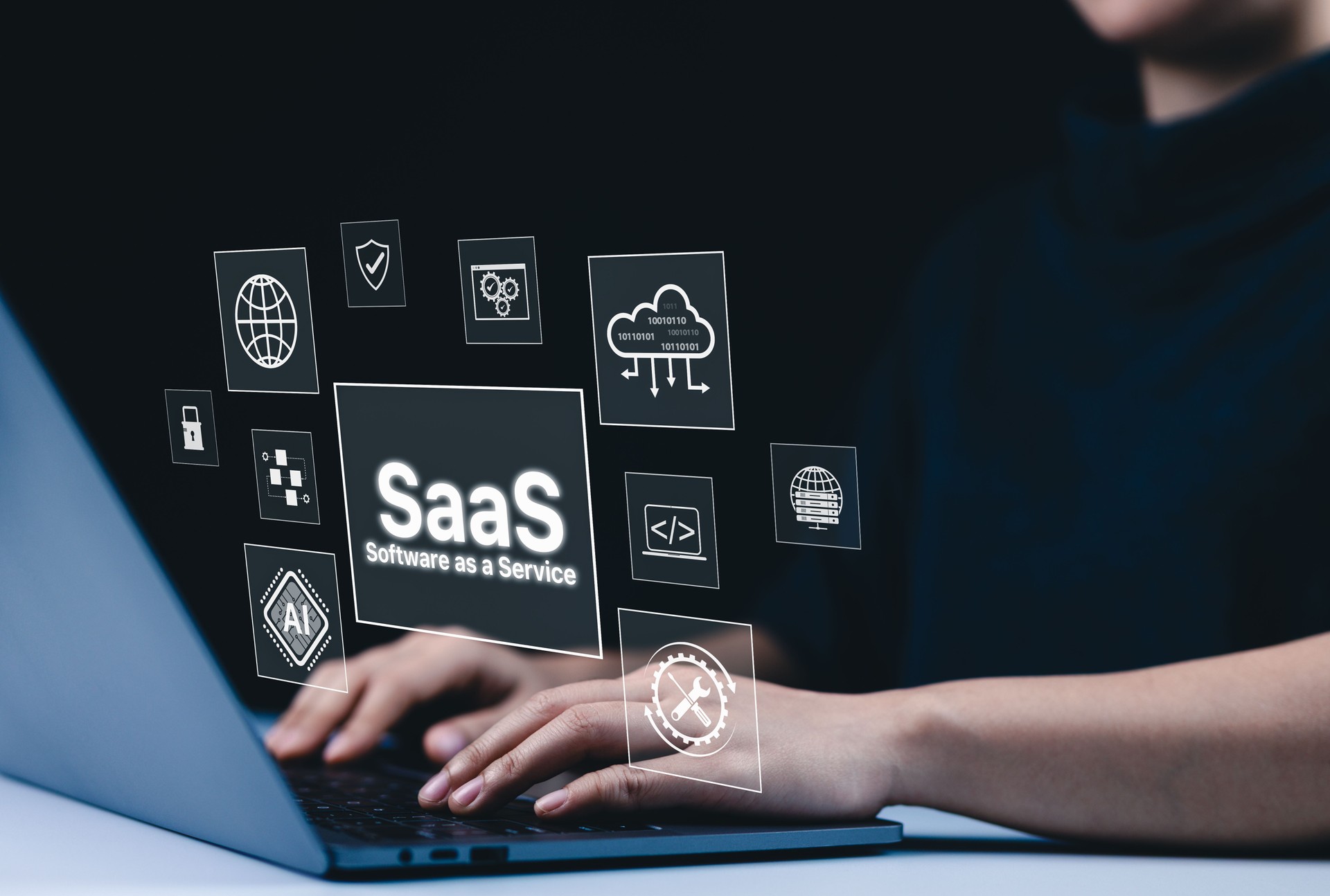 SaaS Cloud Computing and Software as a Service Concept. A person using a laptop with virtual interface icons showing SaaS, cloud computing, AI, and software integration. modern technology platforms,