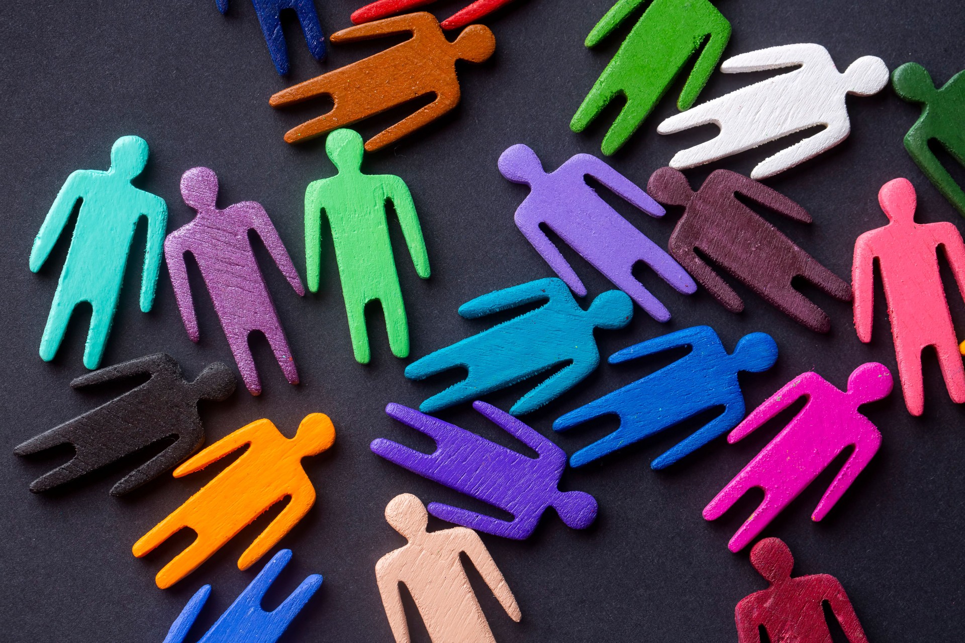 Equality and diversity concept. Multi-colored wooden figurines on a blackboard.
